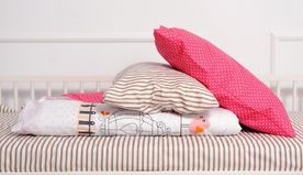 pillow and blanket stacked on bed