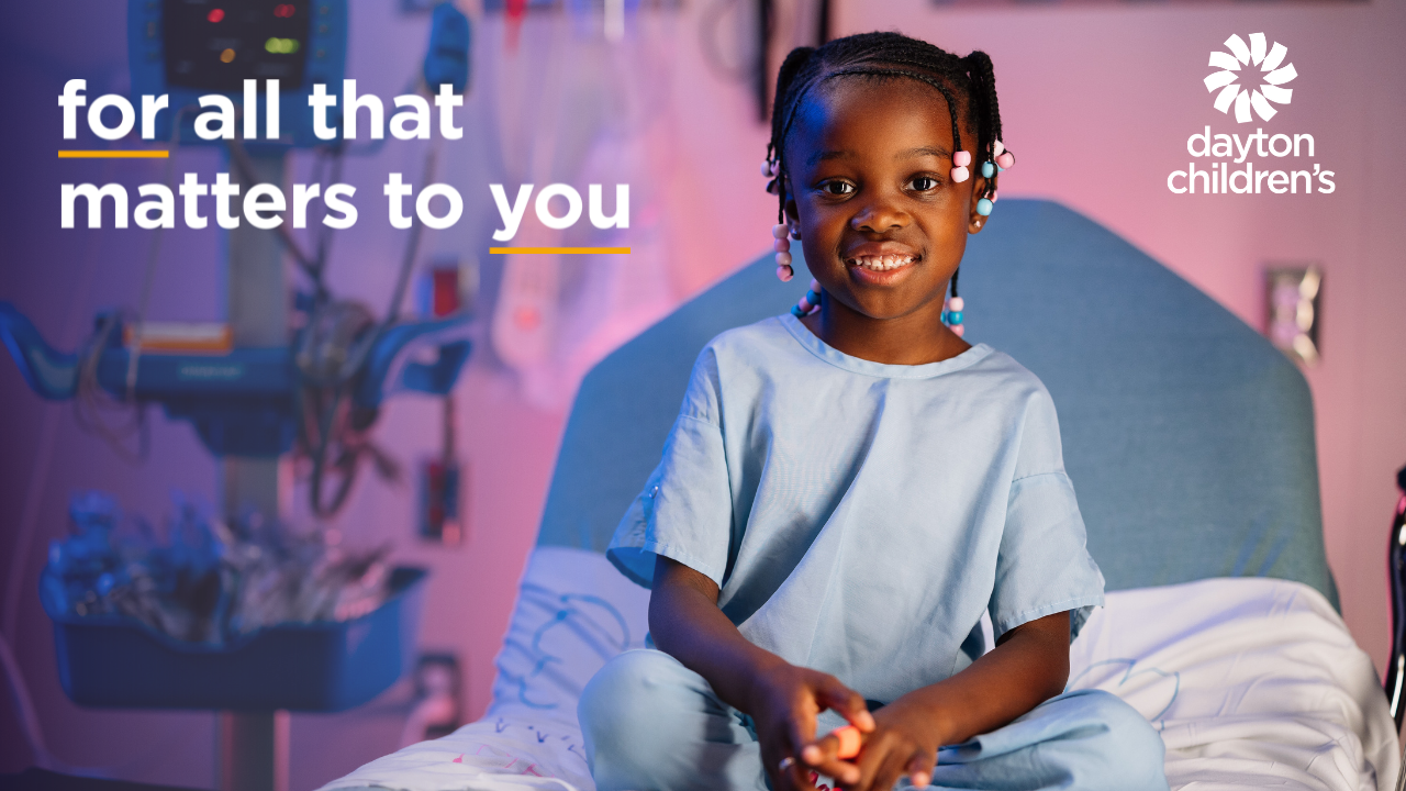 girl sitting on a bed at Dayton Children's Hospital