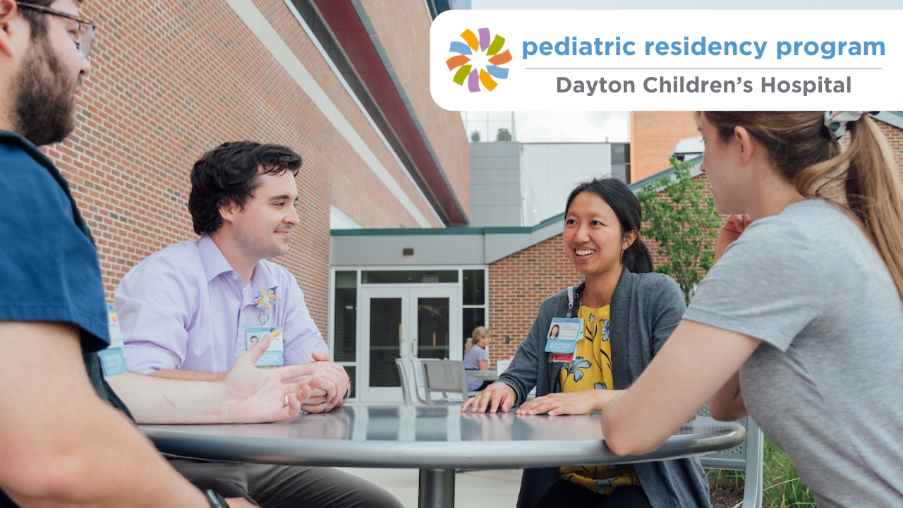 group of residents discussing their education while enjoying time outside at Dayton Children's Hospital