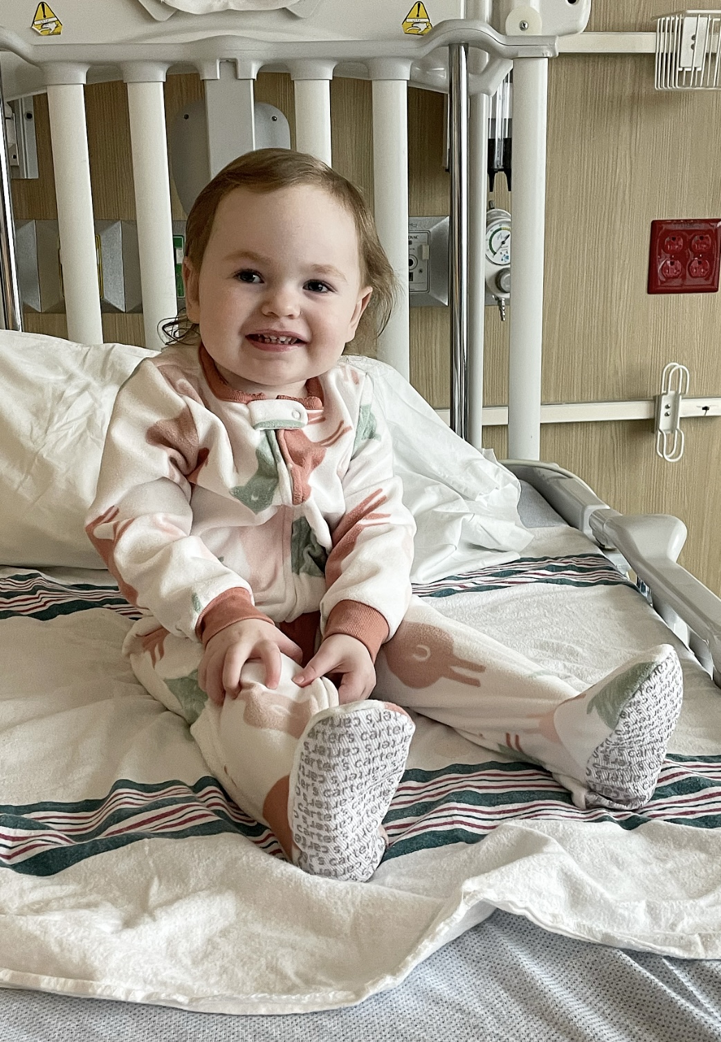 ava coder sitting up in the hospital bed smiling after aHUS treatment