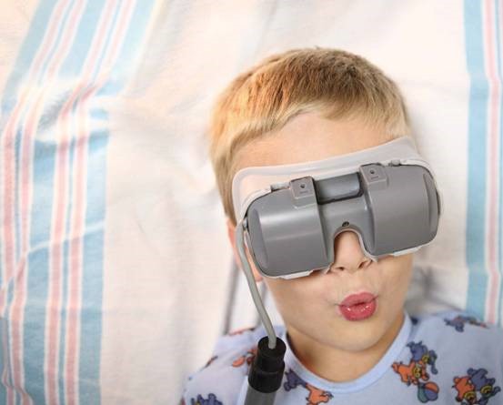 child with solid gray goggles over his eyes