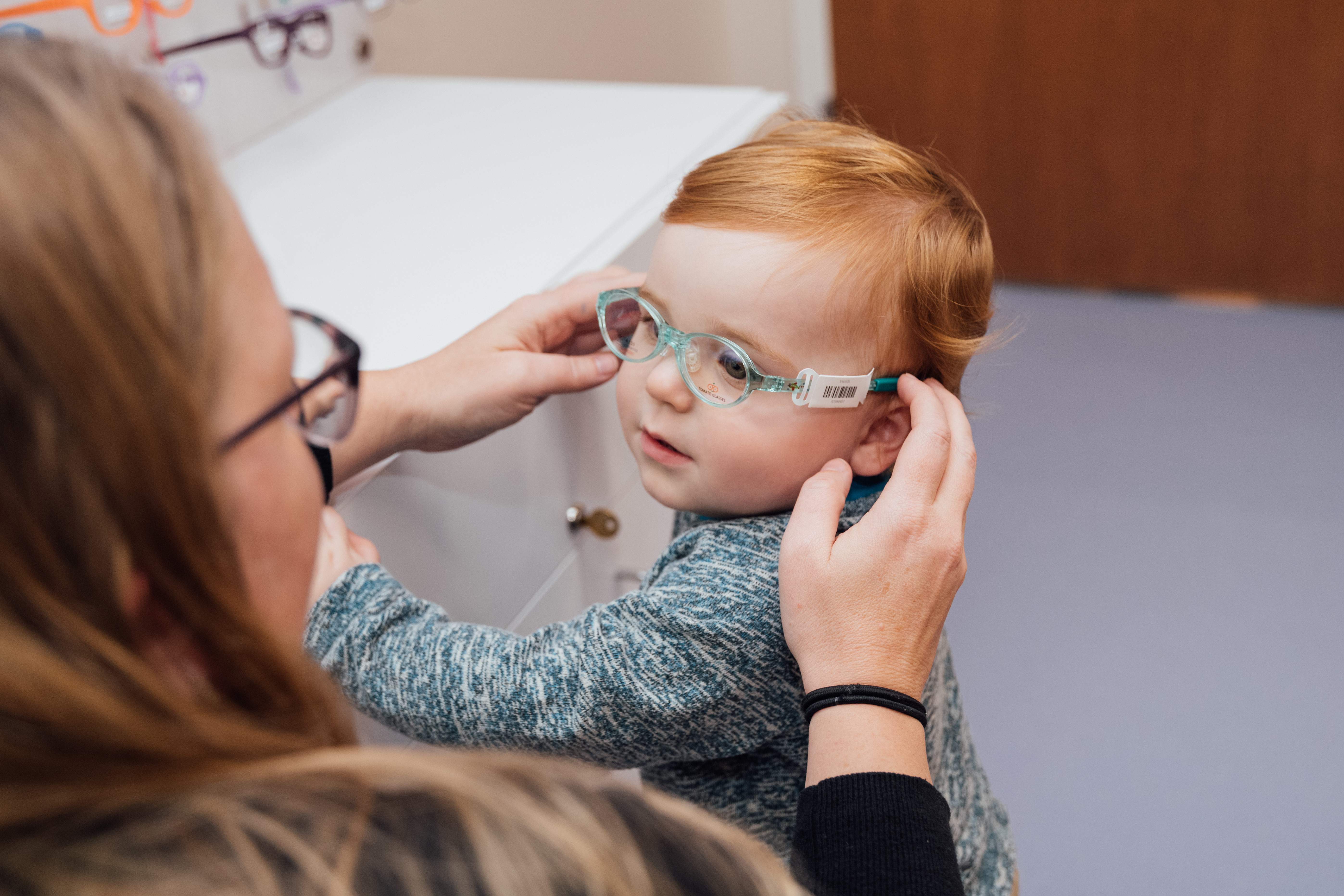 toddler being fit for glasses 