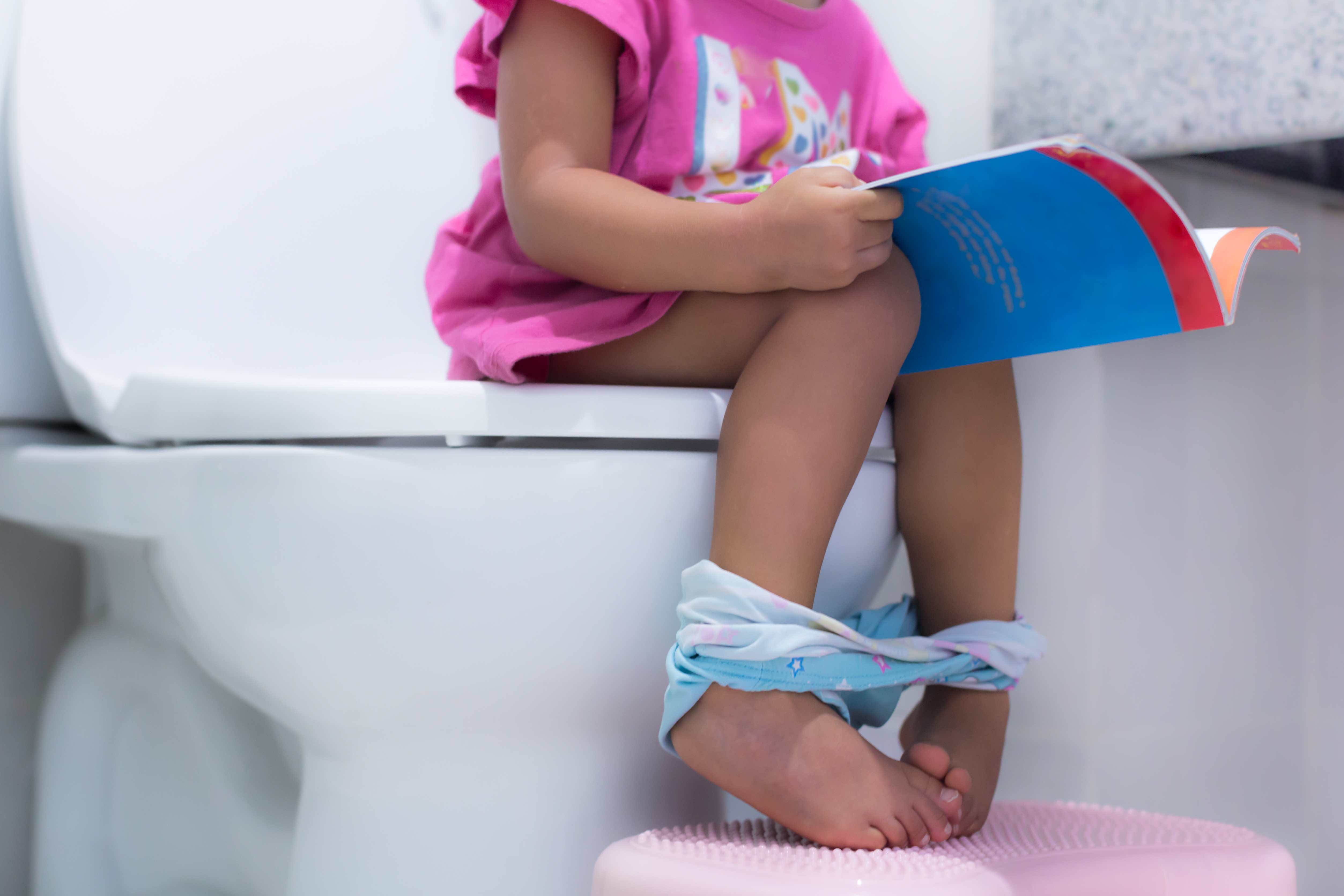 child sitting on toilet
