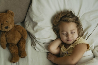 little girl sleeping with teddy bear iStock-1363681019