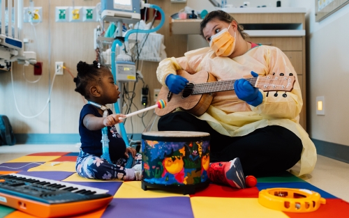 Music therapy playing guitar for patient