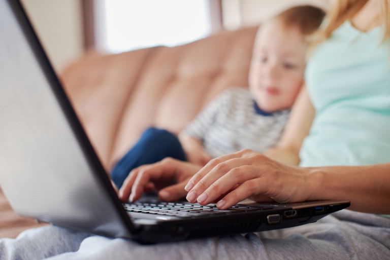 mother on computer with son next to her