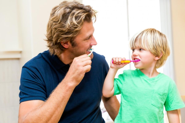 Dad and boy brushing teeth