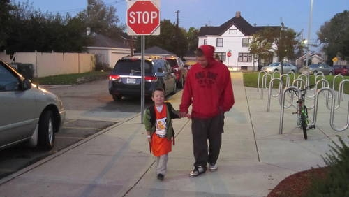 dad and son walking to school