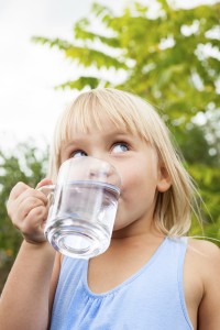 Child drinking water outdoors